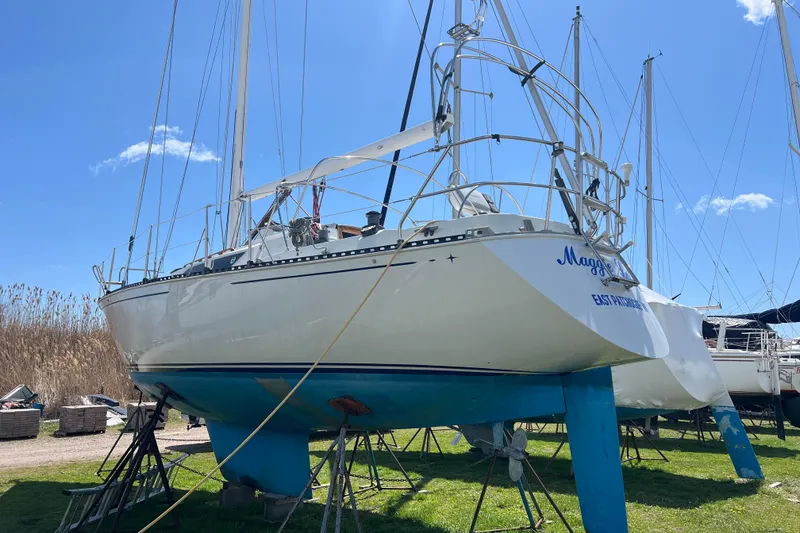 Slide: The Image of 1987 C&C Mark III sailboat on stands, clear sky, grassy yard. - 18