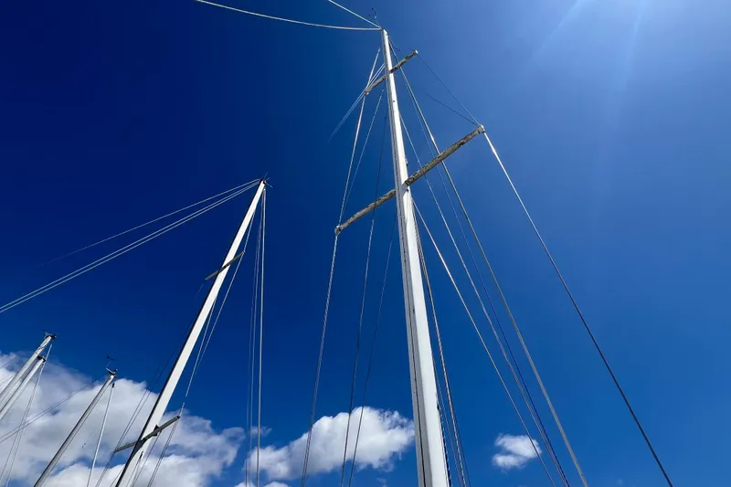 Slide: The Image of Tall sailboat masts against a clear blue sky, C&C Mark III, 1987 model. - 25