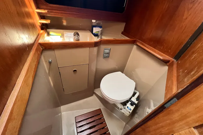 Slide: The Image of Compact 1987 C&C Mark III boat bathroom with wooden accents and marine toilet. - 44