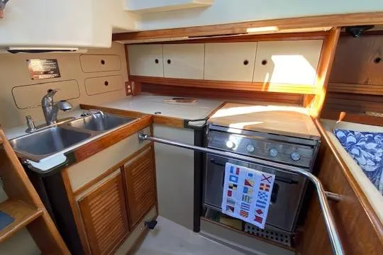 Slide: The Image of Compact 1987 C&C Mark III yacht kitchen with sink, stove, and storage cabinets. - 5