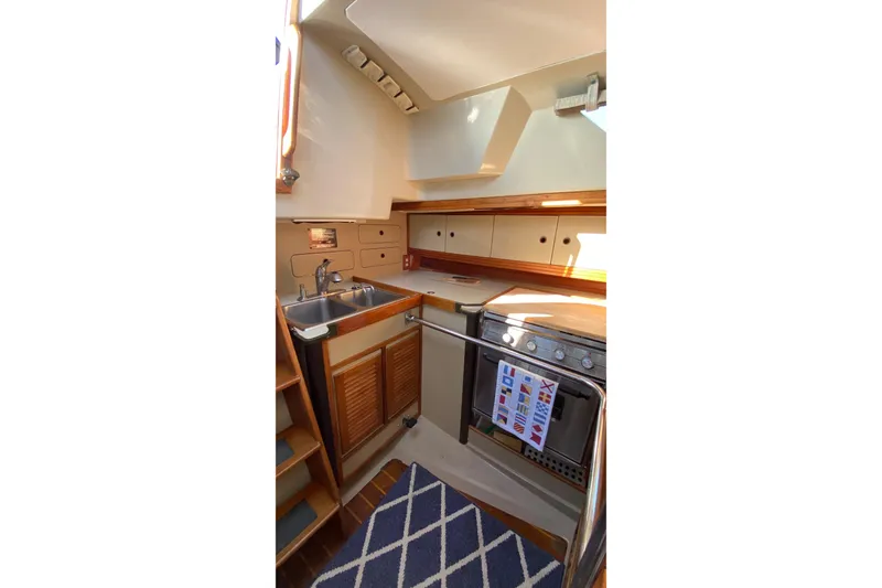 Slide: The Image of 1987 C&C Mark III yacht kitchen with sink, stove, and wooden cabinetry. - 8