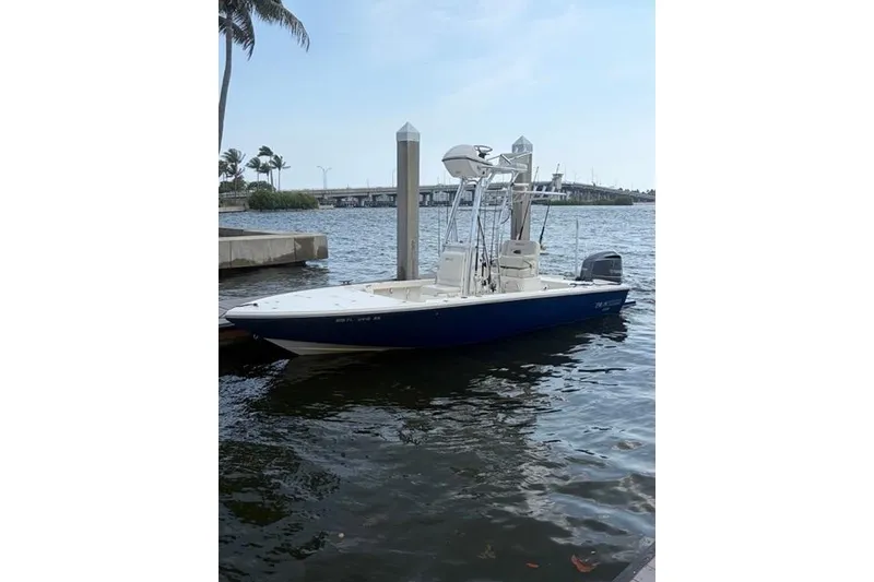 The Image of 2018 Pathfinder 2500 Hybrid boat docked on calm water near a bridge. - 0