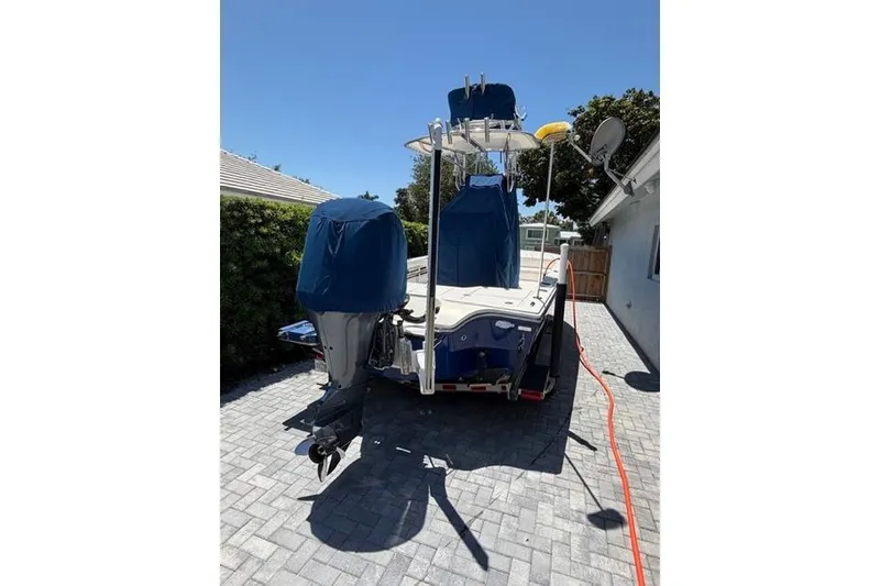 Slide: The Image of 2018 Pathfinder 2500 Hybrid boat parked on a paved driveway, covered and ready for transport. - 12