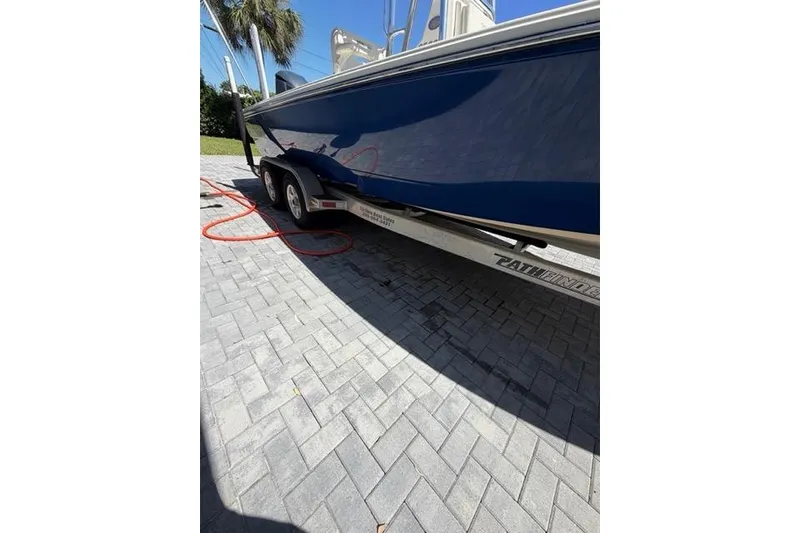 Slide: The Image of 2018 Pathfinder 2500 Hybrid boat on trailer, parked on paved driveway. - 20