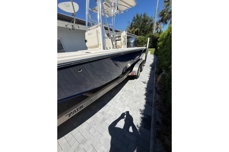 Slide: The Image of 2018 Pathfinder 2500 Hybrid boat on trailer, parked on a paved driveway. - 3