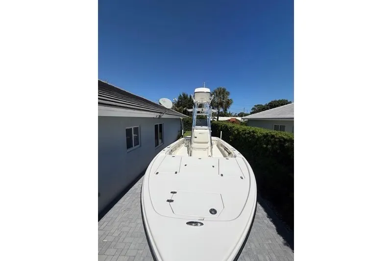 Slide: The Image of 2018 Pathfinder 2500 Hybrid boat on driveway under clear blue sky. - 6