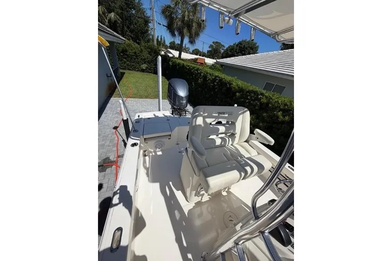 Slide: The Image of 2018 Pathfinder 2500 Hybrid boat with seating and outboard motor in a sunny driveway. - 9