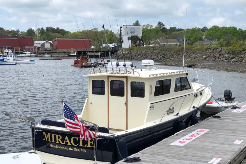 Slide: The Image of 2017 Eastern 35 Casco Bay boat docked, displaying American flag, in a scenic harbor setting. - 5