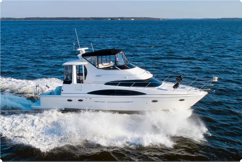 The Image of 2003 Carver 444 Cockpit Motor Yacht cruising on open water. - 0