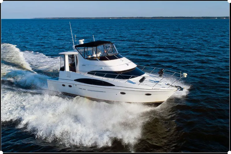 Slide: The Image of 2003 Carver 444 Cockpit Motor Yacht cruising on open water. - 1