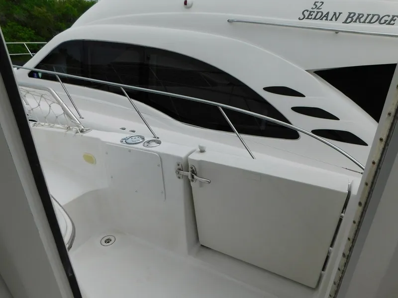 Slide: The Image of 2003 Carver 444 Cockpit Motor Yacht, white exterior, docked beside another yacht. - 15