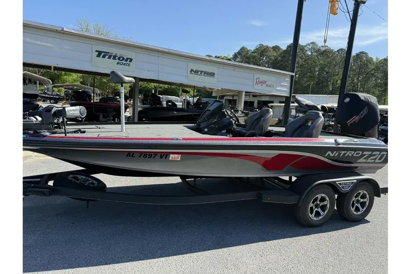 The Image of 2023 Nitro Z20 Pro boat on trailer, parked at dealership with Triton and Ranger signs. - 0