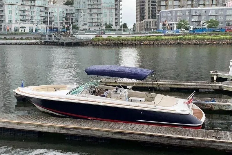 The Image of 2002 Chris Craft 28 Launch boat docked in urban marina setting. - 1