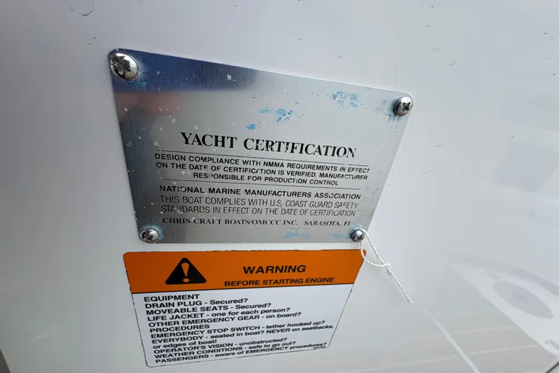 Slide: The Image of Yacht certification plaque on a 2002 Chris-Craft Launch 28 boat with safety warnings. - 10
