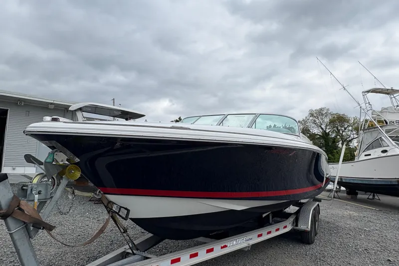 Slide: The Image of 2002 Chris-Craft Launch 28 boat on trailer, parked outdoors under cloudy sky. - 18