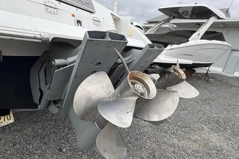 Slide: The Image of 2002 Chris-Craft Launch 28 boat propellers on gravel, with another boat in the background. - 19