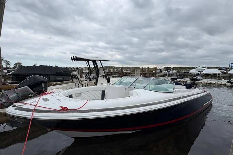 Slide: The Image of 2002 Chris-Craft Launch 28 boat docked at a marina under cloudy skies. - 6