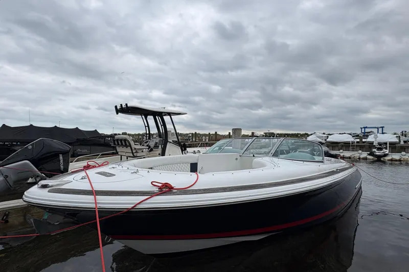 Slide: The Image of 2002 Chris-Craft Launch 28 boat docked under cloudy skies at a marina. - 7