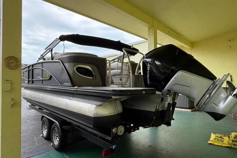 Slide: The Image of 2022 Barletta Lusso 23QCSS pontoon boat on trailer, featuring a Mercury outboard motor. - 11