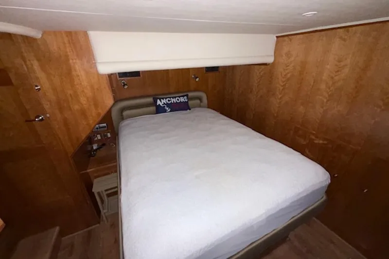 Slide: The Image of Cozy bedroom in 2006 Navigator 53 Extended Deckhouse yacht with wood paneling and plush bedding. - 13