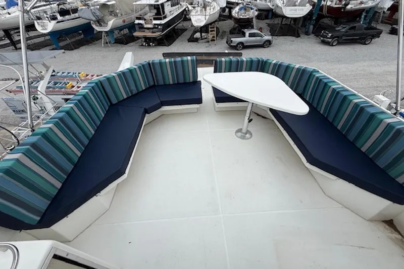 The Image of Spacious deck seating on 2006 Navigator 53 Extended Deckhouse yacht with striped cushions and table. - 2