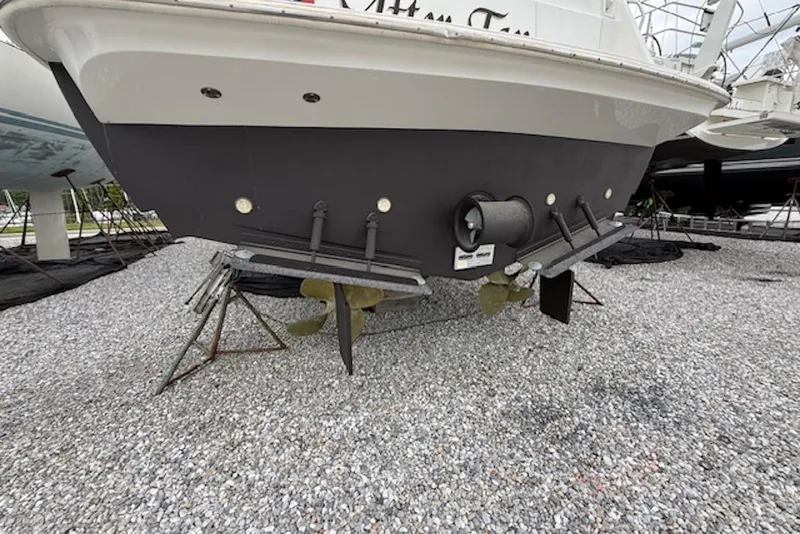 Slide: The Image of Rear view of a 2006 Navigator 53 Extended Deckhouse yacht on gravel, showcasing propellers and rudders. - 21