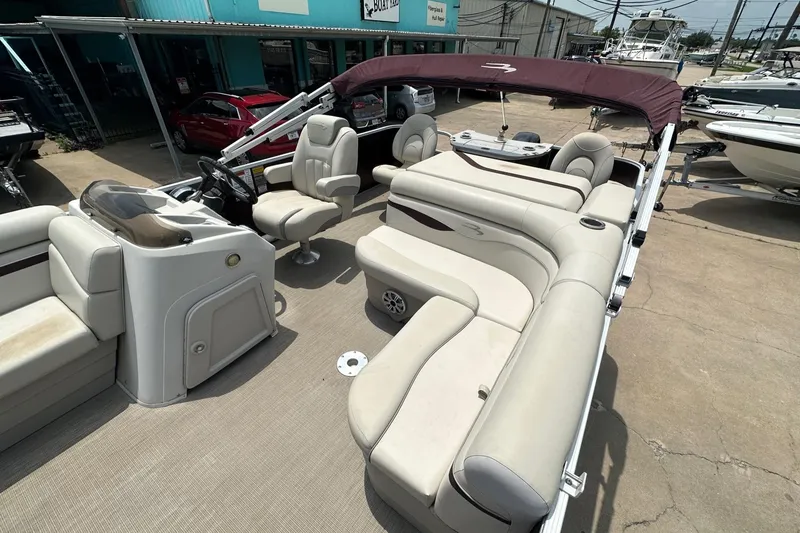 Slide: The Image of 2018 Bennington 20 SX Fish pontoon boat with beige seating and maroon canopy. - 14