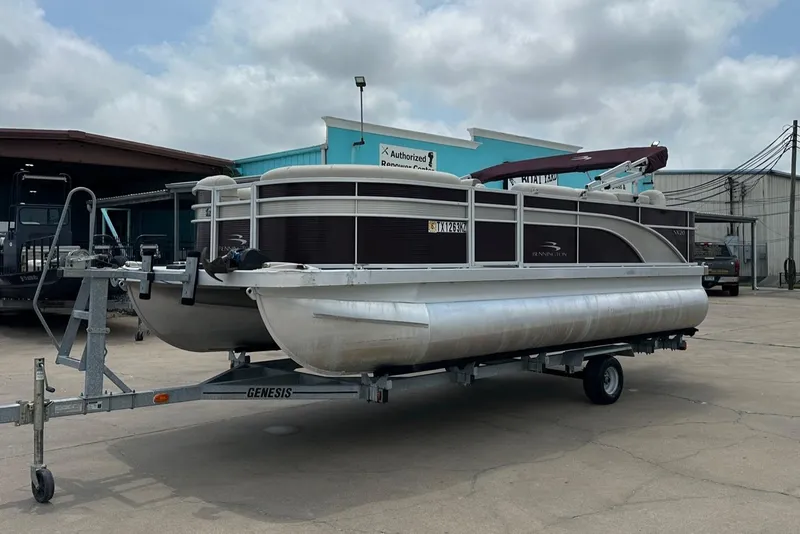 Slide: The Image of 2018 Bennington 20 SX Fish pontoon boat on trailer, parked outdoors. - 8