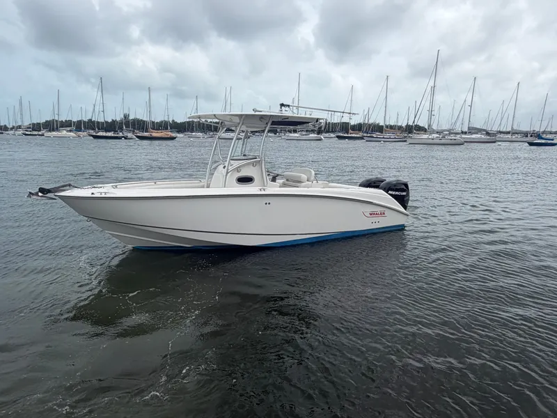 Slide: The Image of 2006 Boston Whaler 240 Outrage on calm water with sailboats in the background. - 4
