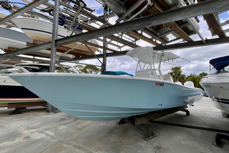 The Image of 2023 Conch 30 boat in storage, light blue hull, outdoor rack setting. - 0