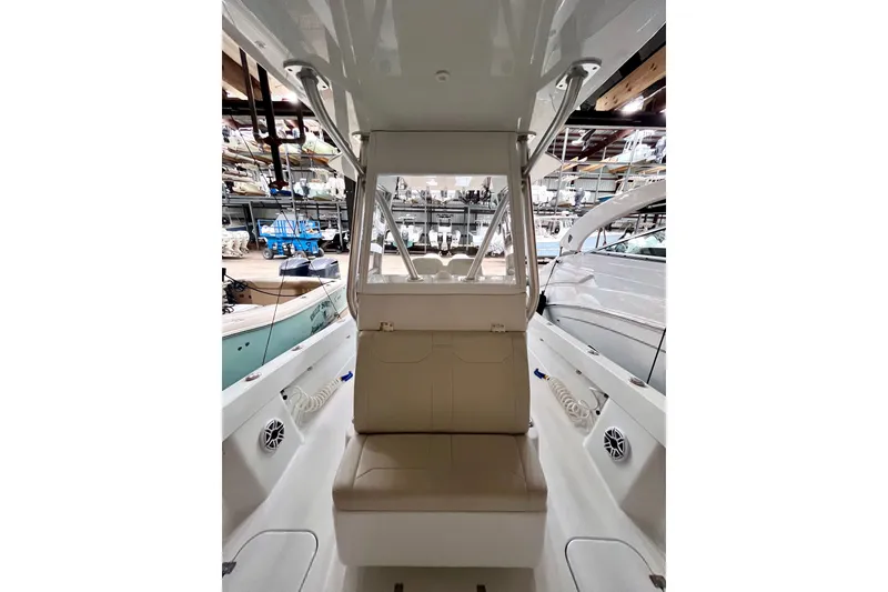 Slide: The Image of 2023 Conch 30 boat interior with seating and storage, docked in a marina. - 13