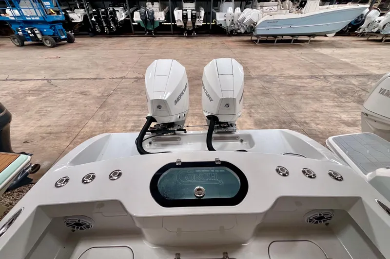 Slide: The Image of 2023 Conch 30 boat with dual Mercury engines in a showroom setting. - 19
