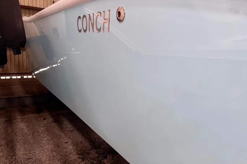 Slide: The Image of 2023 Conch 30 boat side view in storage, showcasing sleek design. - 24