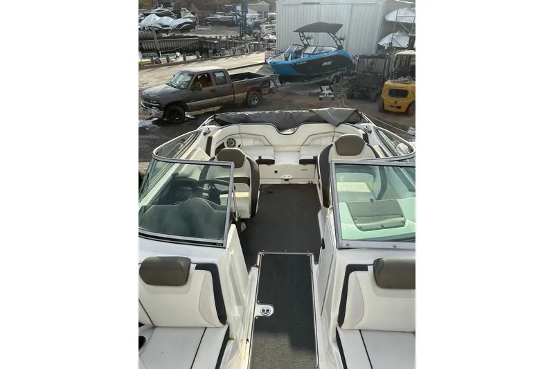Slide: The Image of 2016 Yamaha Boats 212SS interior view at a marina with parked vehicles. - 12