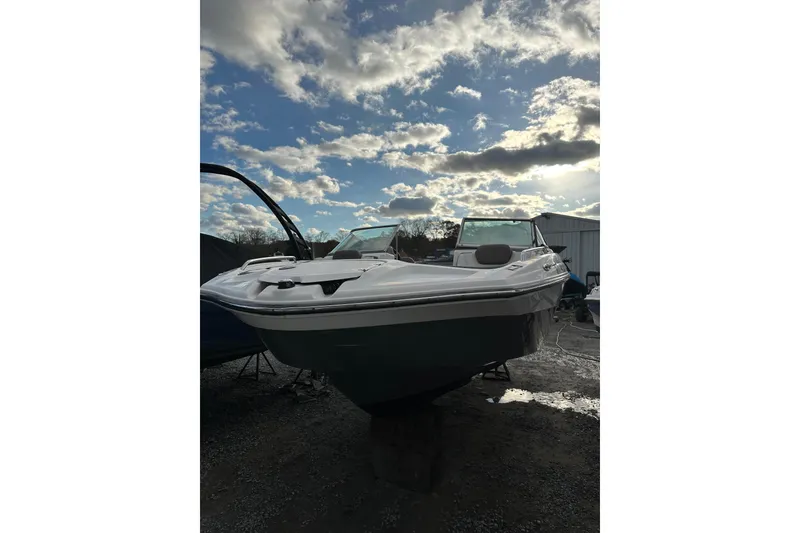 Slide: The Image of 2016 Yamaha Boats 212SS under a cloudy sky, parked on gravel. - 4