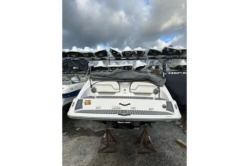 Slide: The Image of 2016 Yamaha Boats 212SS in storage, rear view under cloudy sky. - 7