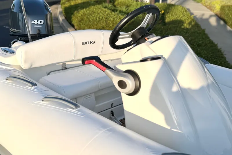 Slide: The Image of 2019 Brig Eagle 340 boat interior with Yamaha 40 engine, featuring sleek white seating and controls. - 19