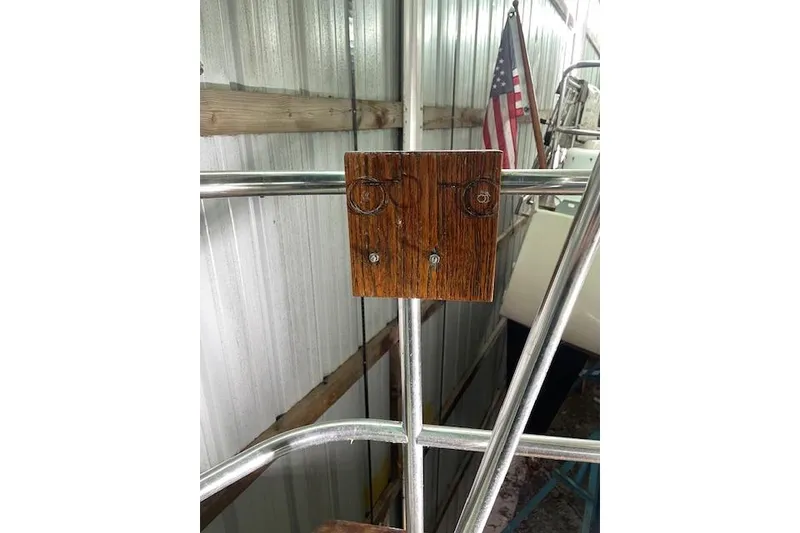 Slide: The Image of Wooden mount on Endeavour 35 sailboat railing, 1984 model, with American flag in background. - 10