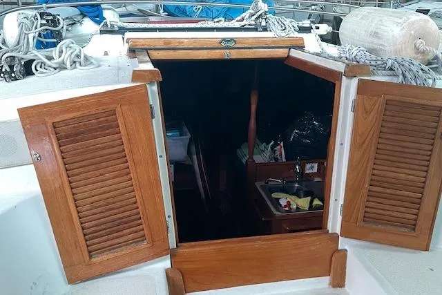 Slide: The Image of 1984 Endeavour 35 sailboat cabin entrance with wooden doors and visible interior. - 15