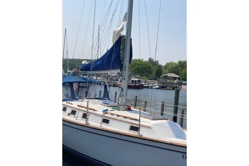 Slide: The Image of 1984 Endeavour 35 sailboat docked at a marina with blue sail cover. - 2