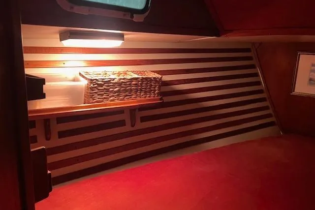 Slide: The Image of Cozy interior of 1984 Endeavour 35 sailboat with wooden accents and wicker basket. - 24