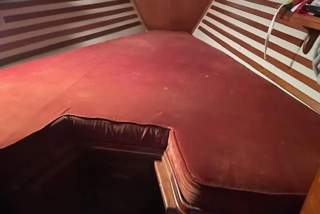Slide: The Image of Interior cabin of a 1984 Endeavour 35 sailboat with red cushioned berth. - 25