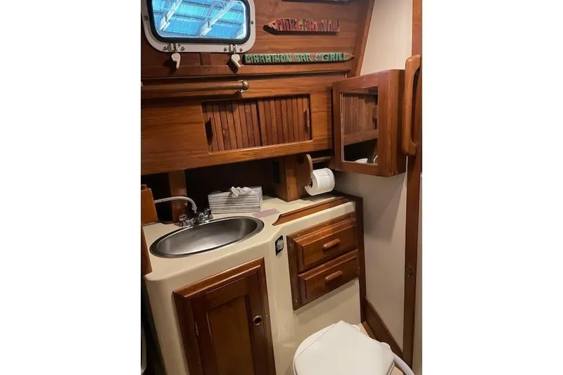 Slide: The Image of 1984 Endeavour 35 yacht bathroom with wooden cabinetry and stainless steel sink. - 26
