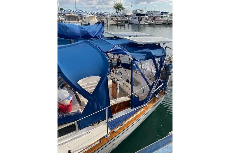 Slide: The Image of 1984 Endeavour 35 sailboat with blue canopy docked at marina. - 3