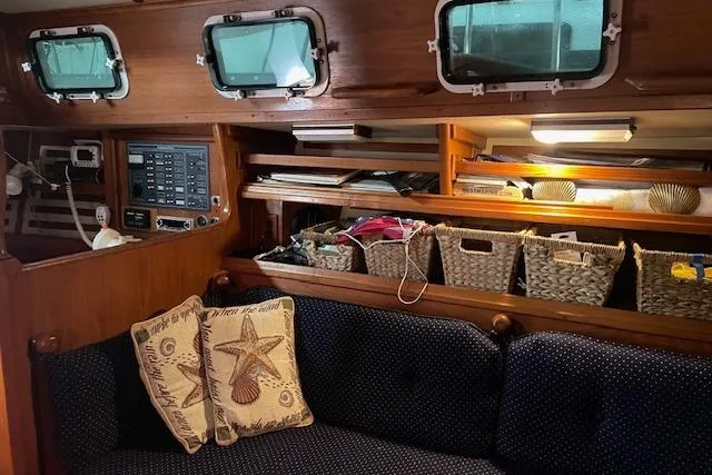 Slide: The Image of Cozy interior of a 1984 Endeavour 35 sailboat with cushions and wicker storage baskets. - 30