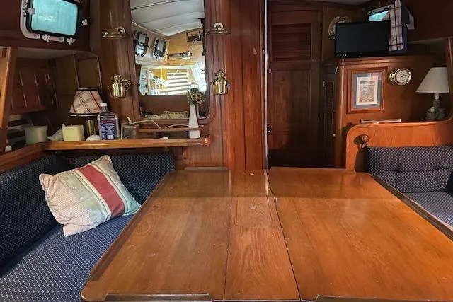 Slide: The Image of Interior of 1984 Endeavour 35 sailboat with wooden furnishings and cozy seating area. - 32