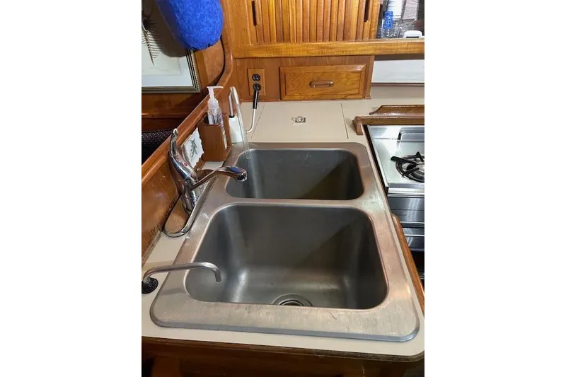 Slide: The Image of Double sink in 1984 Endeavour 35 yacht kitchen with wooden cabinetry. - 33