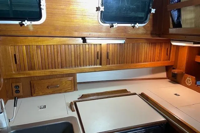 Slide: The Image of Interior of 1984 Endeavour 35 sailboat with wooden cabinetry and compact kitchen area. - 35