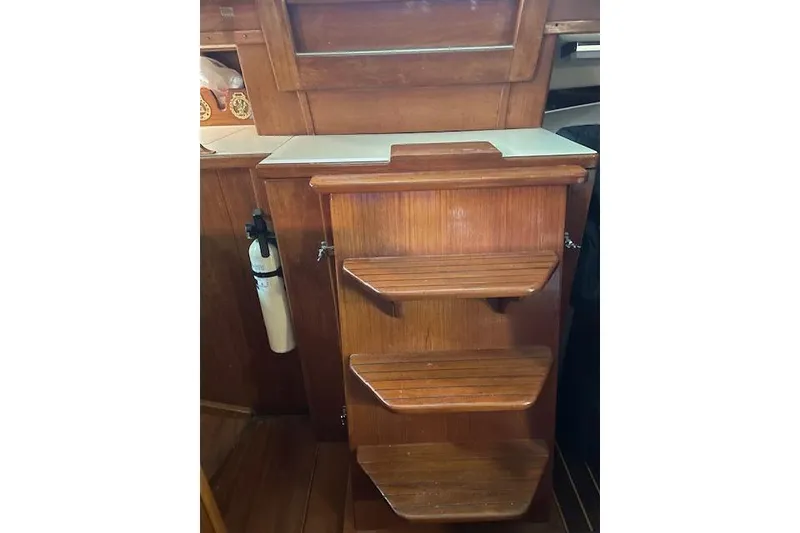 Slide: The Image of Wooden interior stairs on a 1984 Endeavour 35 sailboat, featuring a compact design. - 38