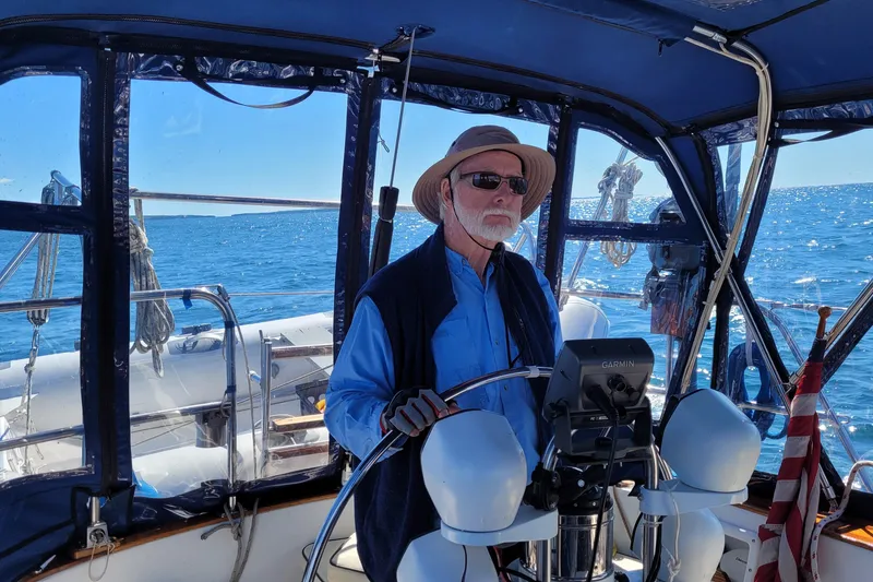Slide: The Image of Man steering 1984 Endeavour 35 sailboat on open sea under clear blue sky. - 9